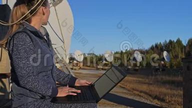 太阳能地面物理研究所女学生操作员在笔记本上监控通信设备。 独一无二