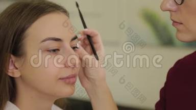 专业化妆师给美容院的客户<strong>画眉</strong>毛。