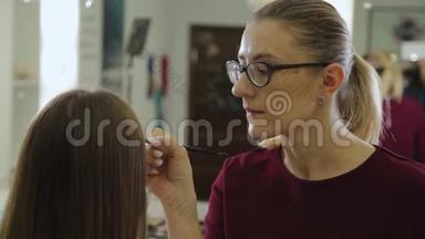 专业化妆师给美容院的客户画眉毛。
