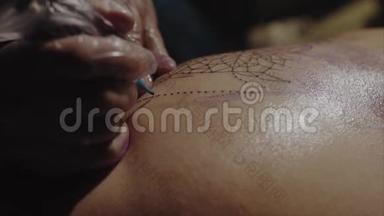 手套上纹身艺术家手的特写，纹身图案在身体宏观上