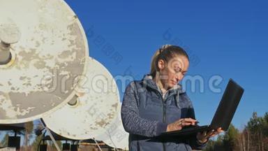 太阳能地面物理研究所女学生操作员在笔记本上监控通信设备。 独一无二