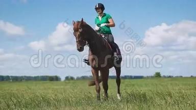 年轻女子骑着马在绿色的田野上