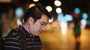 亚洲旅游男子在街头夜间用照相机拍照