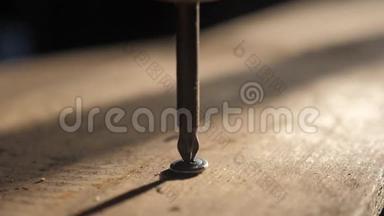 工人用螺丝刀拧紧螺丝。 螺丝起子拧在木板上。 细木工和建筑