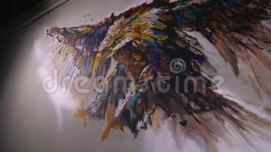 艺术家设计师在墙上画一只鹰。 工匠装饰师用丙烯酸油彩画一幅画。 画家