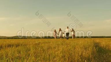 妈妈，爸爸和<strong>小</strong>女儿带着<strong>姐姐</strong>在阳光下田野里散步.. 快乐的年轻家庭。 孩子们，爸爸和妈妈