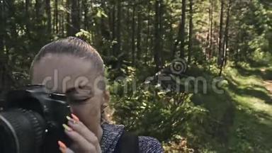游客在森林中拍摄风景。 一个高加索女人近距离射击。 女孩在dslr上拍照
