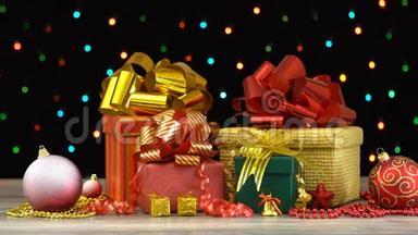 漂亮的圣诞礼品盒和装饰放在木地板上，黑色背景上有五颜六色的闪光花环