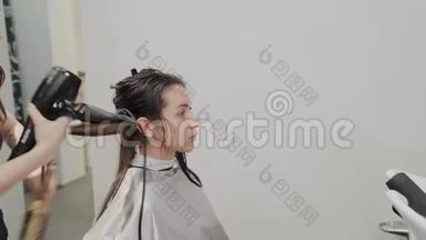 女理发师用吹风机给客户理发。