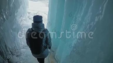 在贝加尔湖冰洞<strong>旅行</strong>的女人。 <strong>去</strong>冬岛<strong>旅行</strong>。 女孩背包客正在冰窟散步。 <strong>旅行</strong>者看起来