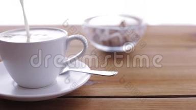 在木桌上倒入咖啡杯的奶油