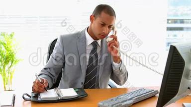 商人在办公桌前工作，写日记