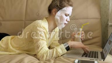 年轻女子带着清洁面罩在家里的笔记本<strong>电脑</strong>后面工作