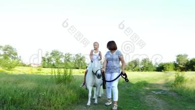 妈妈和女儿在田里走来走去，女儿骑着一匹<strong>小马</strong>，妈妈抱着一匹<strong>小马</strong>做缰绳