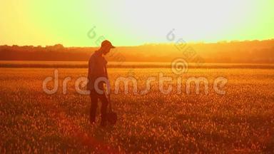 农夫拿着铲子走在田野上。 他们携带种植树木的设备。 在日落的时候。 侧视图