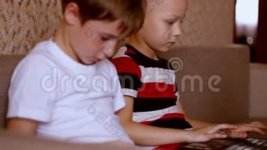 两个男孩在家玩平板电脑和笔记本电脑