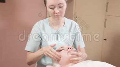 戴着面具和手套的女美容师给一个有魅力的女人做一个有益健康的面部按摩。 <strong>新一代</strong>