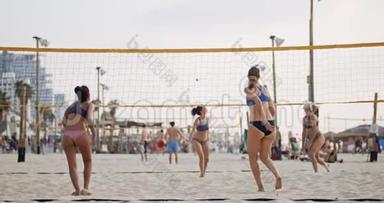 日落时分，女子打沙滩排球的动作缓慢