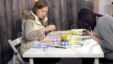 两名成年女子在<strong>艺术学校</strong>用彩色丙烯酸颜料作画