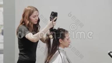 女理发师用<strong>吹风机</strong>给客户理发。
