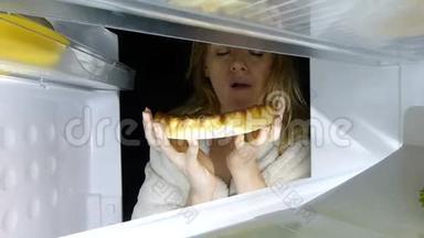 女人晚上打开冰箱。 暴食症，三明治，糕点