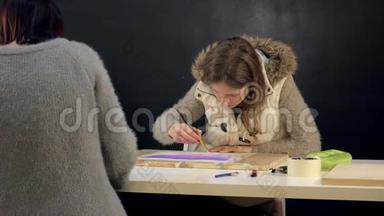 两名成年女子在艺术学校用彩色丙烯酸颜料作画