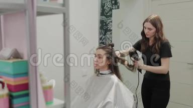 女理发师用吹风机给客户理发。