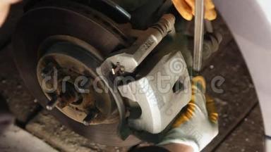 汽车机械师在一家汽车修理店的国内车库里踩刹车。
