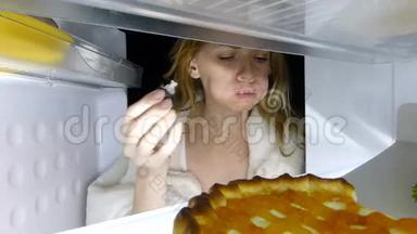 女人晚上打开冰箱。 暴食症，三明治，糕点