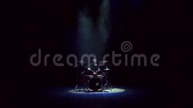 男鼓手在黑色背景上打鼓。