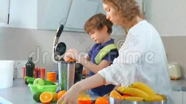 年轻的白种人母亲和孩子在厨房用电榨汁机制作鲜橙果汁