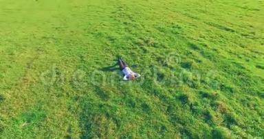 低轨道飞行围绕着绿草上的人与笔记本垫在黄色的农村田野。