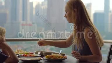 年轻的一家人在摩天大楼的阳台上吃早餐、午餐，可以看到整个市中心