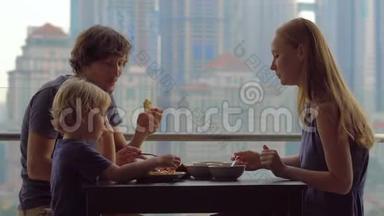 年轻的一家人在摩天大楼的阳台上吃早餐、午餐，可以看到整个市中心