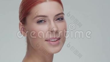 工作室肖像年轻，美丽和自然红发妇女应用护肤霜。 面部提升，化妆品和制作