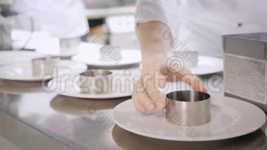 盘子的特写. 集团厨师在精致餐厅的商业厨房忙碌。 餐厅的员工