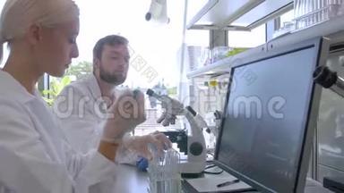 科学家和在实验室工作的学生。 医生带教实习生做分析研究.. 实验室工具：显微镜