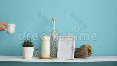 <strong>现代</strong>客房装饰与<strong>相框</strong>模型。 白色的架子靠在粉绿色的墙上，瓶中有蜡烛和岩石。 手