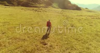 飞行背包徒步旅行游客走过青山野。 夏日的乡村山谷。