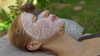 年轻女人用蜗牛粘液做面膜。 在面具上爬行的蜗牛
