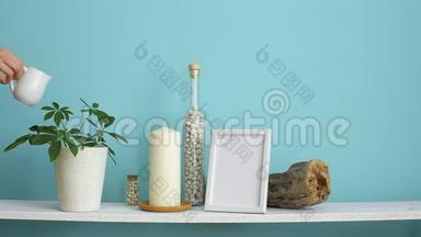 现代客房装饰与相框模型。 白色的架子靠在粉绿色的墙上，瓶中有蜡烛和岩石。 手