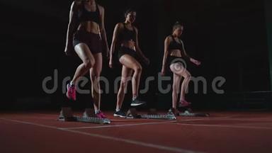 田径场的女跑运动员在比<strong>赛前</strong>蹲在起点。 动作缓慢。