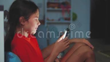 有智能手机的小女孩躺在床上睡觉。 在家里上网玩智能<strong>手机网</strong>络游戏的小女孩