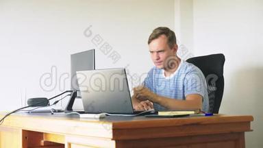 一个男人坐<strong>在家</strong>里的<strong>办公</strong>桌前，<strong>在家</strong>里的电脑和笔记本电脑里工作。