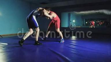 两个摔跤手希腊罗马摔跤在蓝色背景慢莫