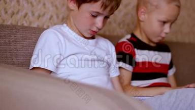 两个男孩在平板电脑和笔记本电脑上玩
