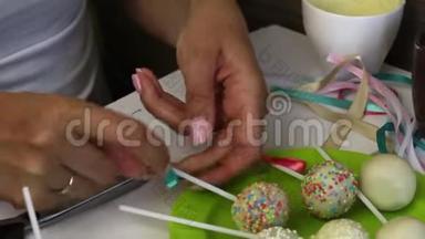 一个女人在盘子里装饰辫子蛋糕的蝴蝶结。 装饰着调料的糖果