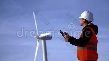 风车能源工程师在日落时与平板电脑合作。 环境