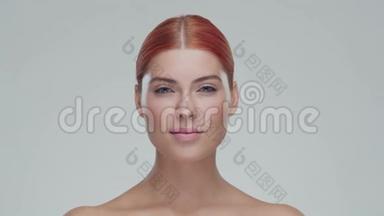 工作室肖像年轻，美丽和自然红发妇女应用<strong>护肤霜</strong>。 面部提升，化妆品和制作