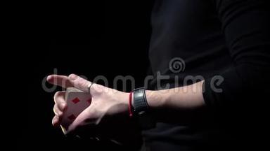 男魔术师用黑色背景的牌表演魔术